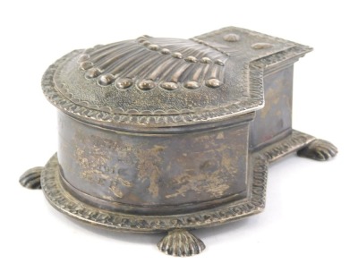 A George V silver inkwell, of shaped form set with a shell with glass insert, partially etched, on hairy paw feet, London 1912, 10cm wide, 5½oz.