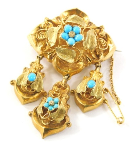 A Victorian blue gold mourning brooch, the central panel with filigree scroll detailing and turquoise set flower emblem, and memorial panel back with three drop elements and safety chain, tests as 18ct on a single pin back, 3cm wide, 5cm high, 13.9g all i