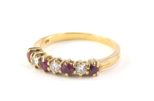 An 18ct gold diamond and ruby half hoop dress ring, set with three round brilliant cut diamonds, totalling approx 0.21cts, and four rubies totalling approx 0.40cts, each in a gold claw setting on an 18ct gold two row band, ring size L½, 2.9g all in, boxed