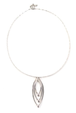 A 9ct white gold modern necklace, the pendant with three loop design, and hammered detailing on an articulated chain, 40cm long, the pendant 6cm high, 10.8g.