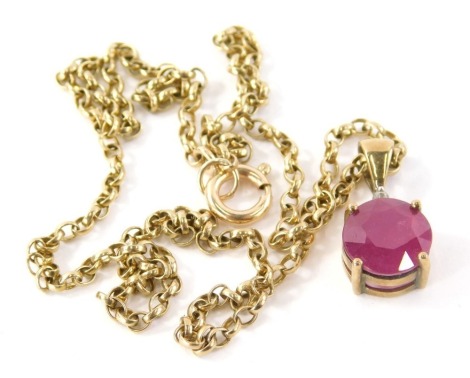 A 9ct gold ruby and diamond pendant and chain, the pendant with round brilliant cut ruby, 9.6mm diameter, 5.4mm deep, with tiny diamond set mount top, the pendant, 2cm high, on a curb link chain marked 375, 66cm long, 7.3g all in.