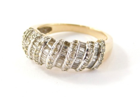 A diamond set dress ring, of half hoop design, with seven rows of round brilliant cut diamonds and six rows of baguette cut stones, in a white gold coloured setting on a yellow metal band, unmarked, believed to be 18ct gold, ring size O½, 5.1g all in.