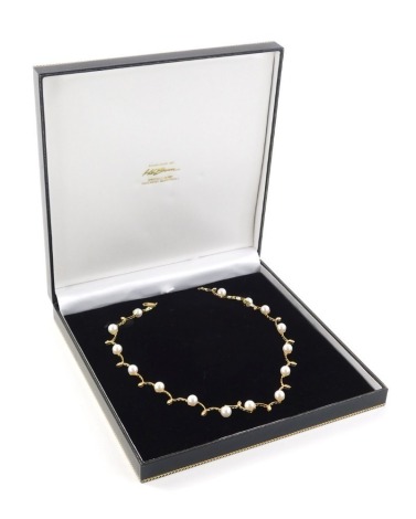 An 18ct gold diamond and pearl necklace, the arch point design set with diamond, with cultured pearl beads, 41cm long, marked 750, 20.8g all in, in a H L Brown of Doncaster box.