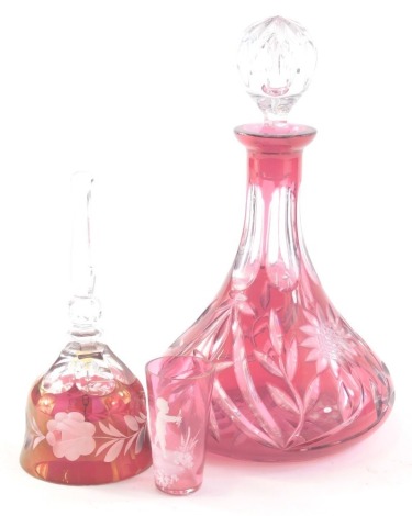 A 20thC ruby and clear glass ship style decanter, with plain glass moulded orb stopper, 30cm high, a Mary Gregory style beaker decorated with child and a flash glass hand bell with frosted glass floral body. (3)