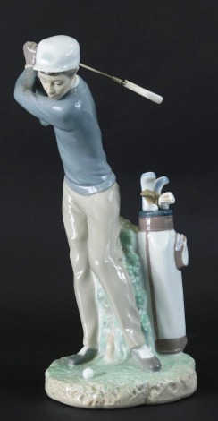 A Lladro pottery figure of a golfer swinging club, printed marks beneath, 28cm high.