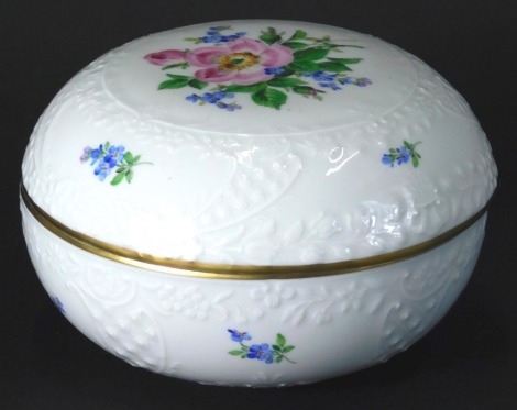 A 20thC Meissen porcelain powder box, of moulded circular form hand painted with flowers predominately in pink, green and blue, double crossed marks beneath, 13cm diameter.