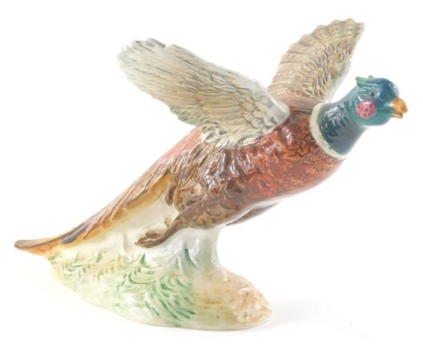 A Beswick figure of a Pheasant, with wings outstretched, number 849 printed and impressed marks beneath, 16cm high.