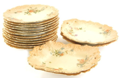 A 19thC Grainger Royal China Works Worcester blush ivory part dessert service, comprising two shaped dishes, 25cm wide, two shaped oval dishes and eleven plates, each hand painted with summer flowers on a blush ivory ground with moulded decorating and gil