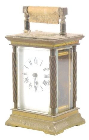 An early 20thC brass carriage clock, with five glass case, set with columns and swing handle, with a Roman numeric dial and visible movement, 13cm high, with key.