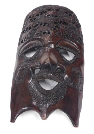 An African tribal face or wall mask, heavily carved with shaped beard, 54cm high.