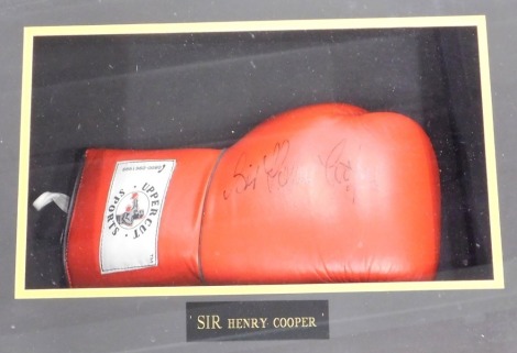 A wall mounted Upper Cuts sports boxing glove, bearing signature Sir Henry Cooper, mounted and framed, 56cm wide.