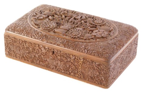 A 20thC Eastern jewellery box, of rectangular form, heavily carved and raised with a central vase of flowers with an outer carving of flower heads, with a part fitted interior, 11cm high, 29cm wide, 18cm deep.