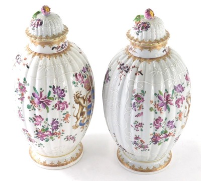 A pair of 19thC Samson Paris porcelain vases, each with compressed domed lids and shouldered circular bodies on circular feet, profusely decorated and raised with scrolls and flowers , in famille rose colours, faux oriental marks beneath, 29cm high. (2)