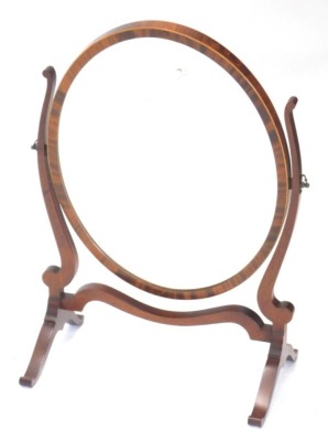 A mahogany and boxwood strung dressing table mirror, the oval bevelled plate on shape supports with splayed feet, 42cm wide.