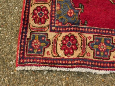 A Persian runner, with a design of medallions on a red ground, one wide border, 325cm x 98cm. - 2