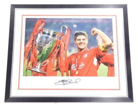 A photographic print of Stephen Gerrard, holding the Champions League trophy bearing signature with certificate, 31cm x 43cm.