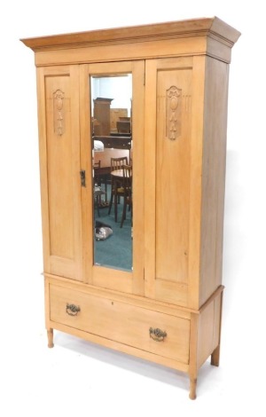 An early 20thC single door wardrobe, the bevel glass flanked by carved columns with fitted interior raised above drawers on turned legs, 195cm high, 120cm wide, 43cm deep.