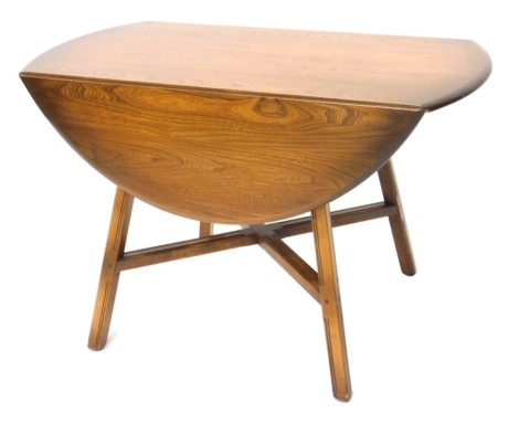 An Ercol oval elm drop leaf table, on tapering supports with X stretcher, 108cm wide.