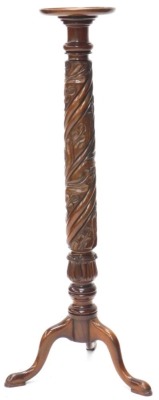 A mahogany torchere, the circular dished top above a leaf and spirally carved column on tripod base with pad feet, 129cm high.