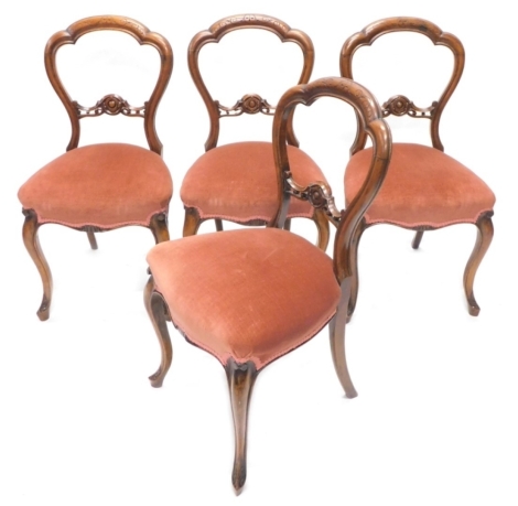 A set of four Victorian walnut balloon back chairs, each with a pink upholstered padded seat on cabriole legs.