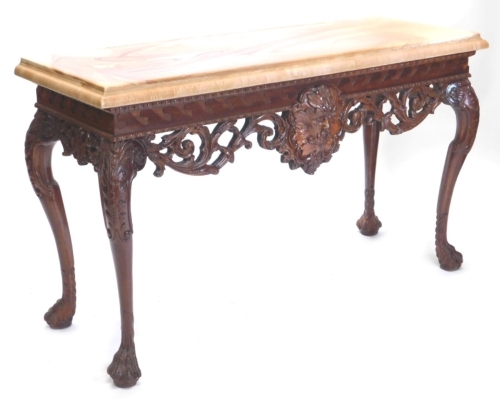 A continental mahogany console table, with a marble effect top, the base carved with a central mask flanked by scrolls, stylised waves, etc., on leaf carved cabriole legs with paw feet, 80cm high, 136cm wide, 49cm deep.