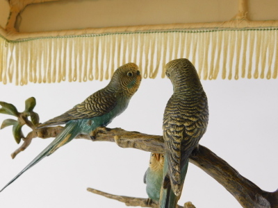 A 1920s cold painted bronze table lamp, set with four budgerigars on entwined floral branches and a green onyx base, 34cm wide, with electrical feature and shade. WARNING! This lot contains untested or unsafe electrical items. It is supplied for scrap o - 8