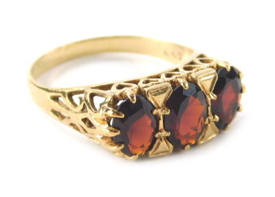 A ladies 9ct gold garnet dress ring, with three claw set faceted cut stones on a pierced shank decorated with hearts, size N-O, 3.3g all in. - 5