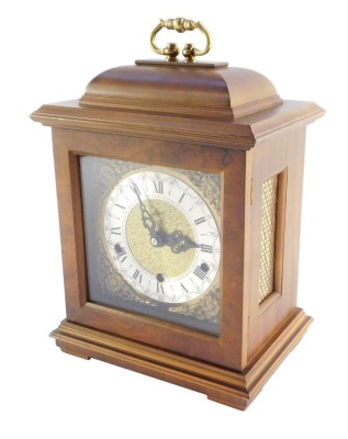 A Schatz walnut cased mantel clock, with square dial having brass spandrels cast as Amorini, chapter ring bearing Roman numerals, eight day movement with Westminster chimes, the case of domed square form, on pad feet, 29cm high, 20cm wide, 14cm deep. - 13