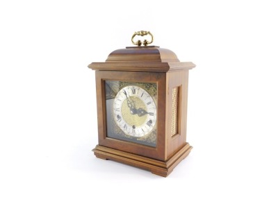 A Schatz walnut cased mantel clock, with square dial having brass spandrels cast as Amorini, chapter ring bearing Roman numerals, eight day movement with Westminster chimes, the case of domed square form, on pad feet, 29cm high, 20cm wide, 14cm deep. - 14