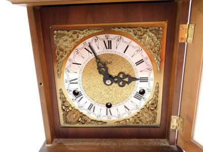 A Schatz walnut cased mantel clock, with square dial having brass spandrels cast as Amorini, chapter ring bearing Roman numerals, eight day movement with Westminster chimes, the case of domed square form, on pad feet, 29cm high, 20cm wide, 14cm deep. - 15