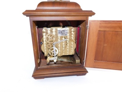 A Schatz walnut cased mantel clock, with square dial having brass spandrels cast as Amorini, chapter ring bearing Roman numerals, eight day movement with Westminster chimes, the case of domed square form, on pad feet, 29cm high, 20cm wide, 14cm deep. - 17