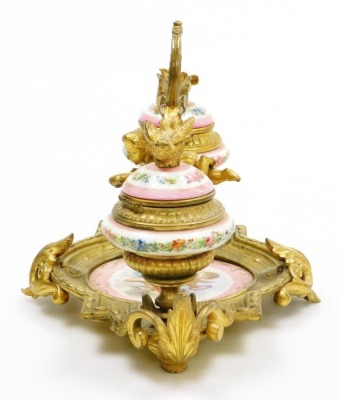 A 19thC French porcelain and ormolu mounted desk stand, possibly Sevres, the central dish painted with a cherub against a pink ground, flanked by two ink pots each cast with bird finials holding a letter in each beak, the porcelain ink pots decorated with - 9