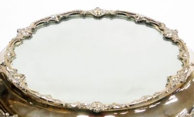 A Victorian silver plated wedding cake stand, with a mirrored top, the base decorated with vacant cartouches and scrolls, raised on four foliate scroll feet, 49cm diameter. - 7