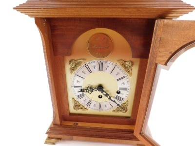 A mahogany cased mantel clock, with arched brass dial, silvered chapter ring with Roman numerals and brass spandrels formed as Amorini, the circular maker's plaque marked D J Hallwood Ely, with a caddy top and brass four point finials, on brass ogee brack - 6