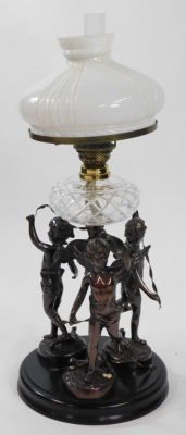 An early 20thC spelter oil lamp, cast as three standing cherubs with ribbons around a central spiral fluted column, raised on a circular ebonised base, with a cut glass reservoir, glass chimney and fluted milk glass shade, 81cm high. - 4