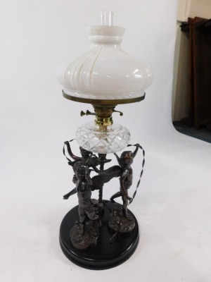 An early 20thC spelter oil lamp, cast as three standing cherubs with ribbons around a central spiral fluted column, raised on a circular ebonised base, with a cut glass reservoir, glass chimney and fluted milk glass shade, 81cm high. - 5