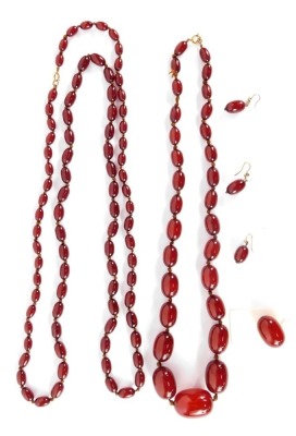 A suite of cherry amber jewellery, comprising graduated beaded necklace, the largest bead 3cm wide, the smallest 1.5cm wide, on a yellow metal clasp, unmarked, together with a matching pair of earrings, and single earring with loose bead, and a further Lo - 4