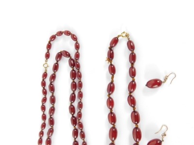 A suite of cherry amber jewellery, comprising graduated beaded necklace, the largest bead 3cm wide, the smallest 1.5cm wide, on a yellow metal clasp, unmarked, together with a matching pair of earrings, and single earring with loose bead, and a further Lo - 6