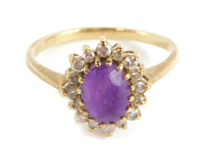 An amethyst and CZ dress ring, with central oval cut amethyst in claw setting, surrounded by halo of tiny CZ stones, in a raised basket setting, yellow metal, unmarked, ring size P, 2.4g all in. - 3