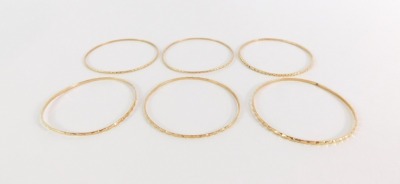 Four Parisian bangles, each of hammered design, yellow metal, unmarked, 28.4g all in, 5cm diameter. - 4