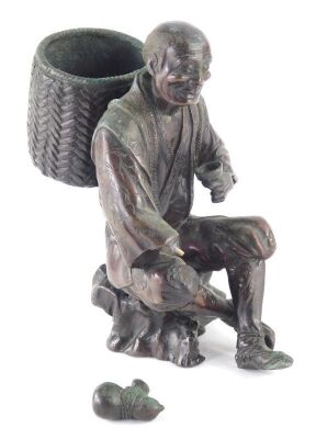 A Japanese bronze figure, Meiji period, modelled in the form of a man holding a gourd and a cup, whilst carrying a basket, unsigned, 17cm high. (AF) - 9