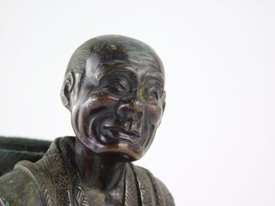 A Japanese bronze figure, Meiji period, modelled in the form of a man holding a gourd and a cup, whilst carrying a basket, unsigned, 17cm high. (AF) - 11