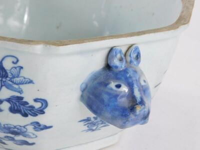 An 18thC Chinese export porcelain octagonal tureen and cover, decorated in underglaze blue with flowers beside a rustic table, the lid with a crown finial, the base with rabbit mask handles, 30cm wide. - 16