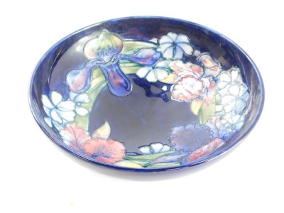 A Moorcroft pottery bowl decorated in the Frilled and Slipper Orchid pattern, against blue ground, painted and impressed marks, 26cm diameter. (AF) - 3