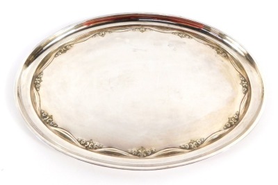 A George V silver oval tray, with embossed Neo Classical floral and drape decoration, Birmingham 1922, 12¼oz, 29cm wide.