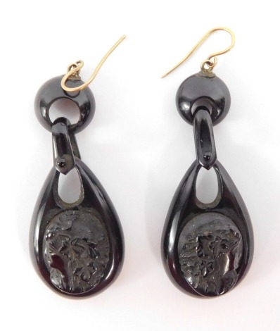 A pair of Victorian jet mourning earrings, of two layered design with tier drop pendant with Neoclassical figure of a female, on yellow metal wire clips, 5.5cm high, 9.5g all in.