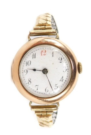 A lady's 9ct gold circular cased wristwatch, the white enamel circular dial in a 9ct gold case with numberings and black handles, on a plated strap, 2.5cm wide, 26g all in.