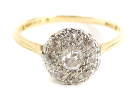 A diamond cluster ring, with central old cut diamond in a rub over setting with outer pave design of tiny diamonds, in a raised basket setting, ring size M, 2.3g all in.