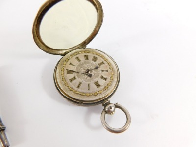 A continental lady's silver pocket watch, open faced, key wind, silvered coloured dial and silver gilt bow outer detailing, bearing Roman numerals, the case engraved with flowers and reserve shield bearing initials ME, 39.9g all in, together with a Samson - 2