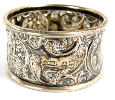 A George V silver napkin ring, with rococo scroll and mask detailing, reserve panel bearing the initials TA, Birmingham 1918, 11.6g all in.